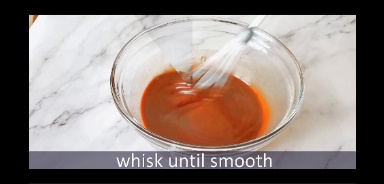 mixing chocolate in a glass bowl using whisk