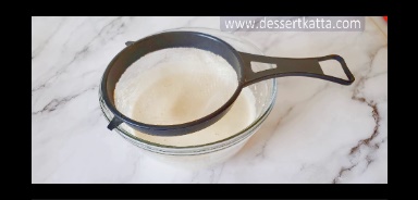 sifting dry ingredients into eggs.