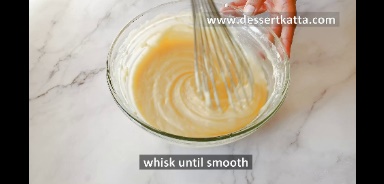 mixing wet and dry ingredients with whisk in a glass bowl