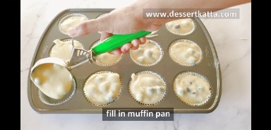 adding lemon blueberry muffin batter to muffin pan using ice cream scoop