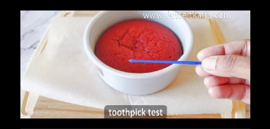 blue toothpick is showing no crumbs with red velvet cake in background