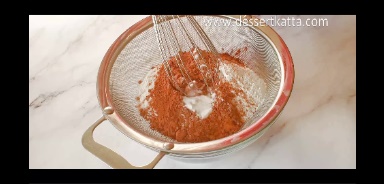 dry ingredients like all-purpose flour, cocoa powder, baking powder, baking soda is sifted using sifter in a glass bowl