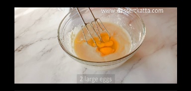 eggs are added to red velvet cake batter in a glass bowl