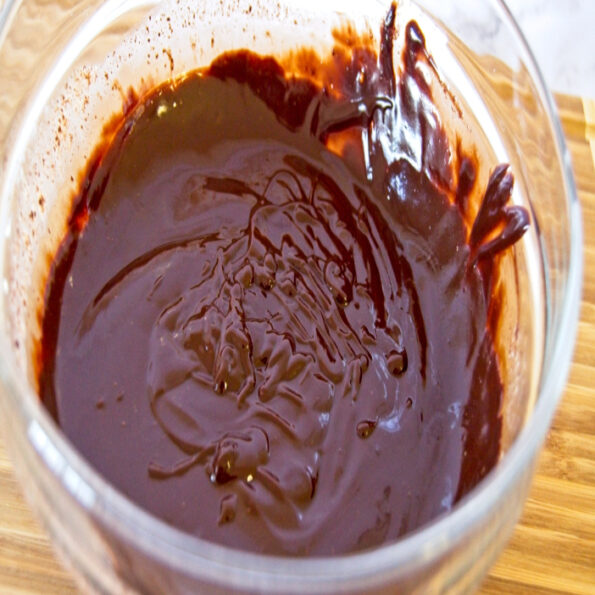 chocolate ganache in a bowl placed on wooden board