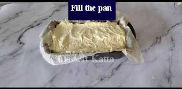pound cake batter is filled in loaf pan lined up with parchment paper