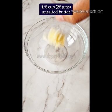 unsalted butter is added to the glass bowl