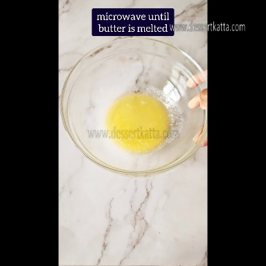 a glass bowl contains melted butter after microwaving