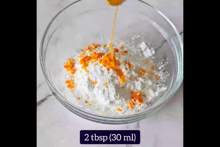 orange glaze recipe ingredients are added to glass bowl