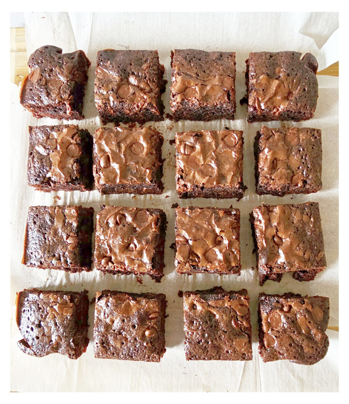top view of 16 pieces of brownies placed on parchment paper
