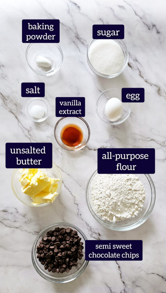 ingredients for no brown sugar cookie with label are placed in glass bowls on marble background