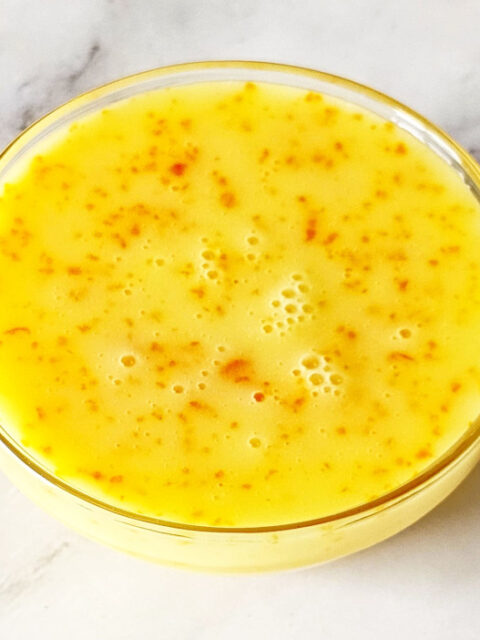 Orange glaze is poured in glass bowl