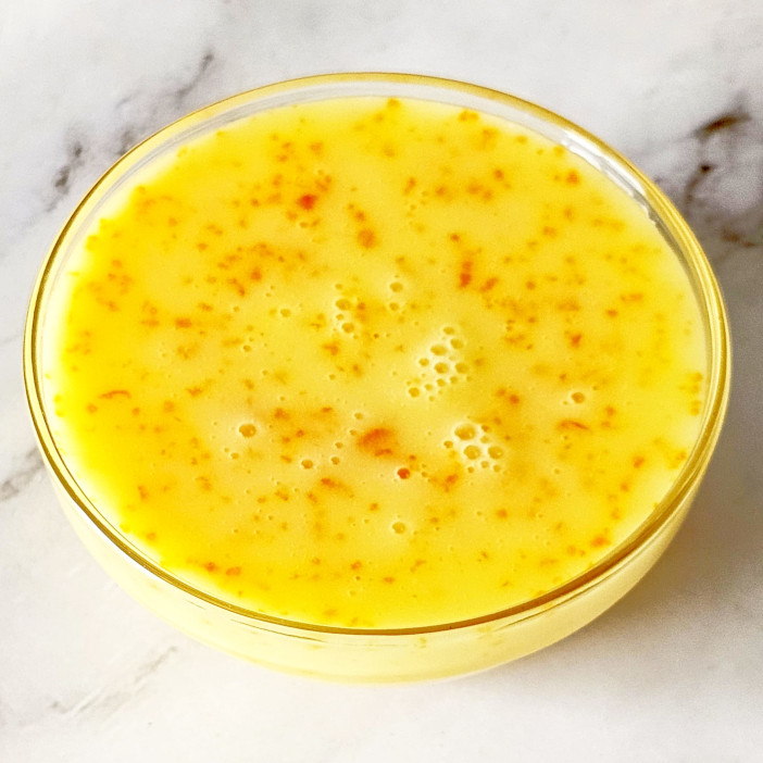 Orange glaze is poured in glass bowl