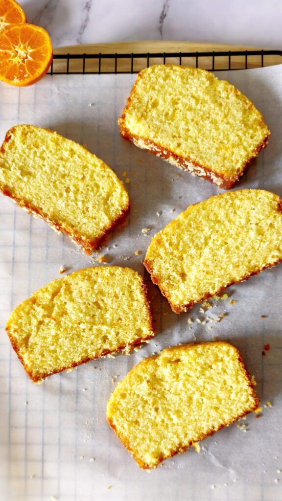individual slices of orange loaf cake is placed on parchment paper