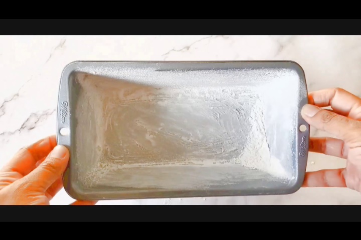 9X5 inch loaf pan is covered with flour from inside