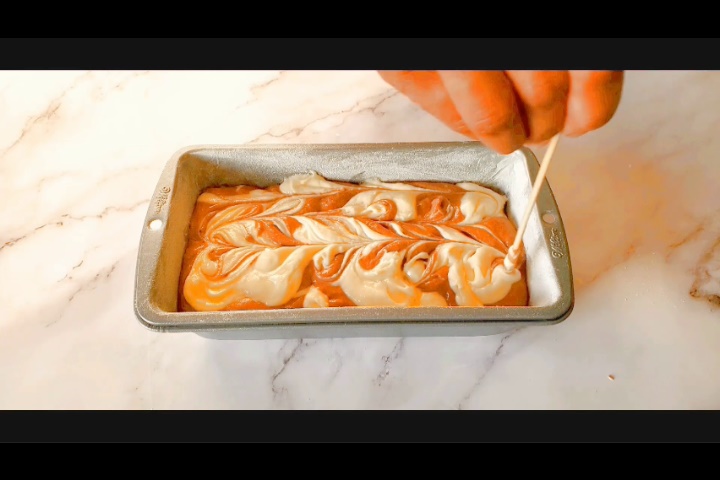 mixing vanilla and chocolate cake batter using toothpick to make marble loaf cake recipe