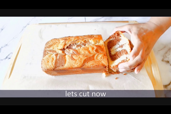 cutting marble loaf cake and showing marble effect from inside