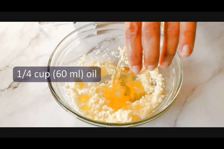 adding 60 ml oil into butter and sugar mixture, one of the steps in marble loaf cake recipe