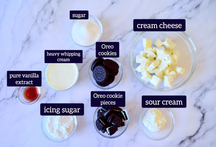 ingredients to make mini Oreo cheesecake is kept in small glass bowls on marble surface