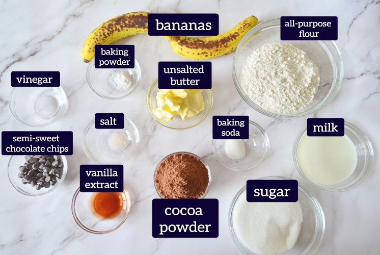 banana chocolate loaf cake ingredients are placed on glass bowl on marble surface