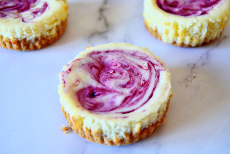 3 mini cheesecakes are placed on white marble background