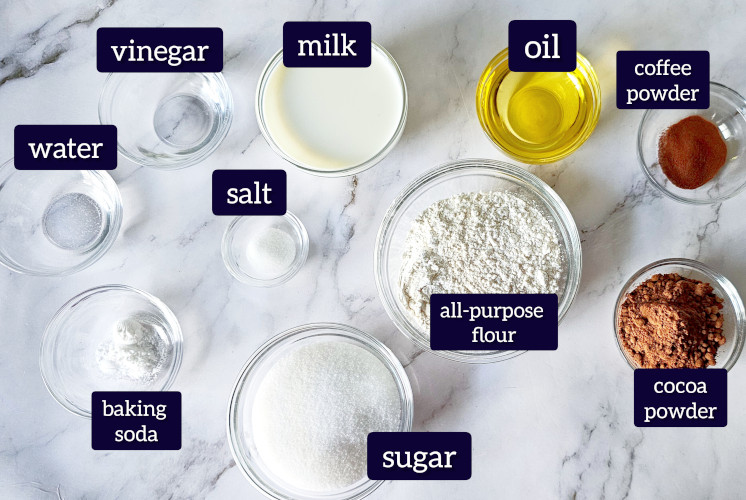 chocolate cupcake ingredients are placed in glass bowls on marble surface