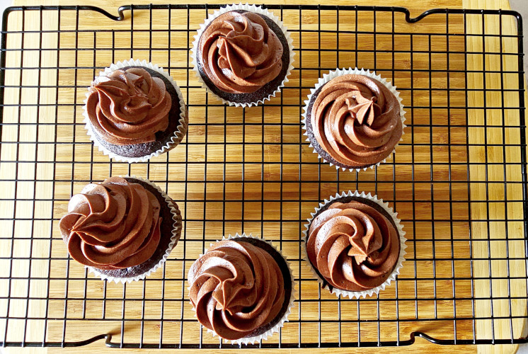 6 chocolate cupcakes with chocolate cream cheese frosting placed on wire rack