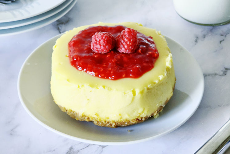 top shot of cheesecake topped with raspberry sauce