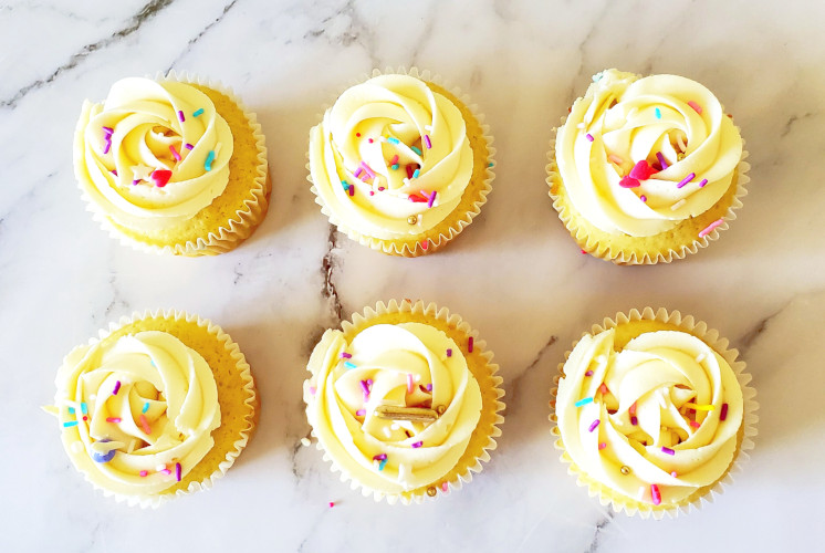 6 vanilla cupcakes decorated with smooth buttercream