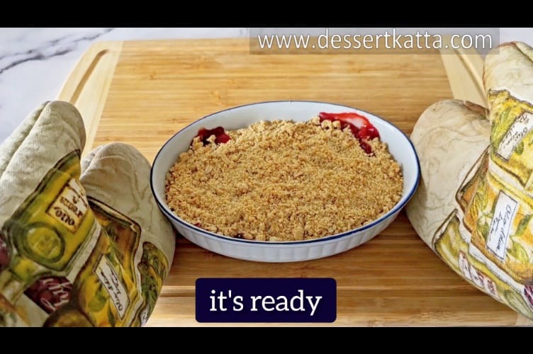 strawberry crumble, just out of the oven is placed on wooden surface