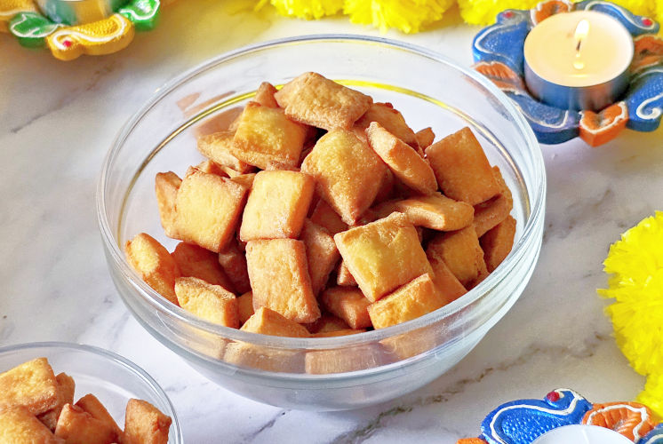 shot of fried shankarpali kept in small glass bowl on marble background