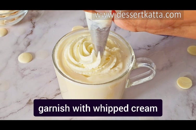 garnishing Starbucks white chocolate mocha with whipped cream