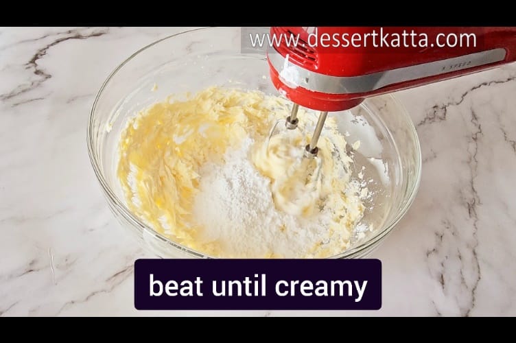 beating icing sugar and butter with a hand beater