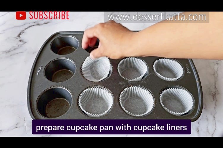 inserting cupcake liners into cupcake pan to make mango cupcake