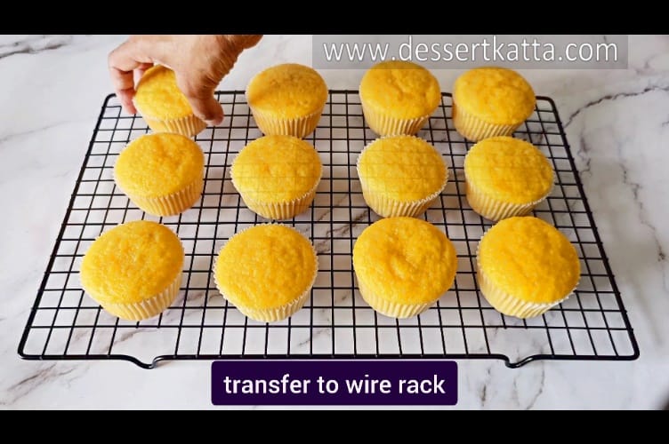 transferring mango cupcakes to wire rack to cool down