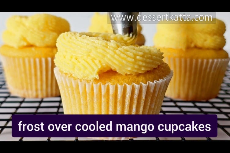 frosting mango cupcakes with mango buttercream