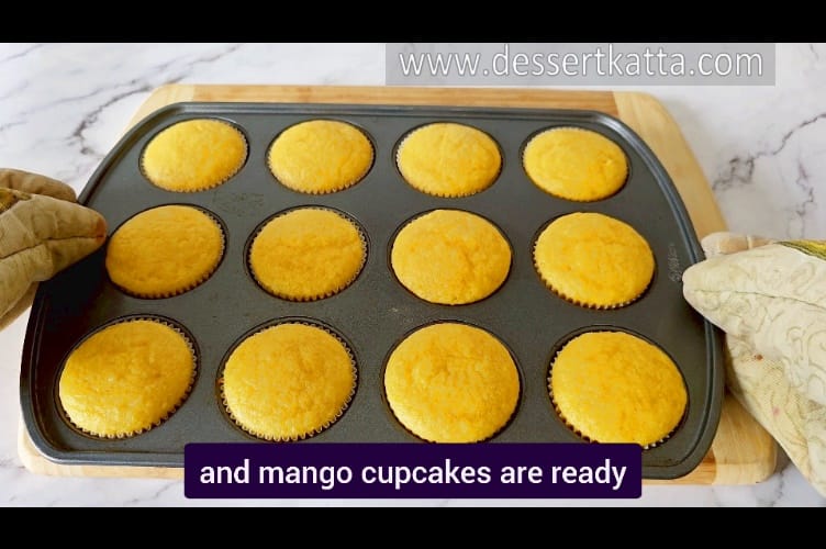 image of 12 freshly baked mango cupcakes